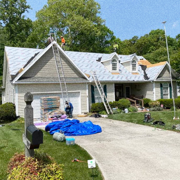 front view of a house with new roofing and gutter getting installed high point nc